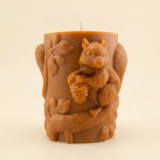 Close-up of the Squirrel Pillar candle from The Angelina Store – a handcrafted caramel pillar candle featuring a detailed woodland squirrel with acorn and leaf design, infused with rich Nag Champa fragrance.